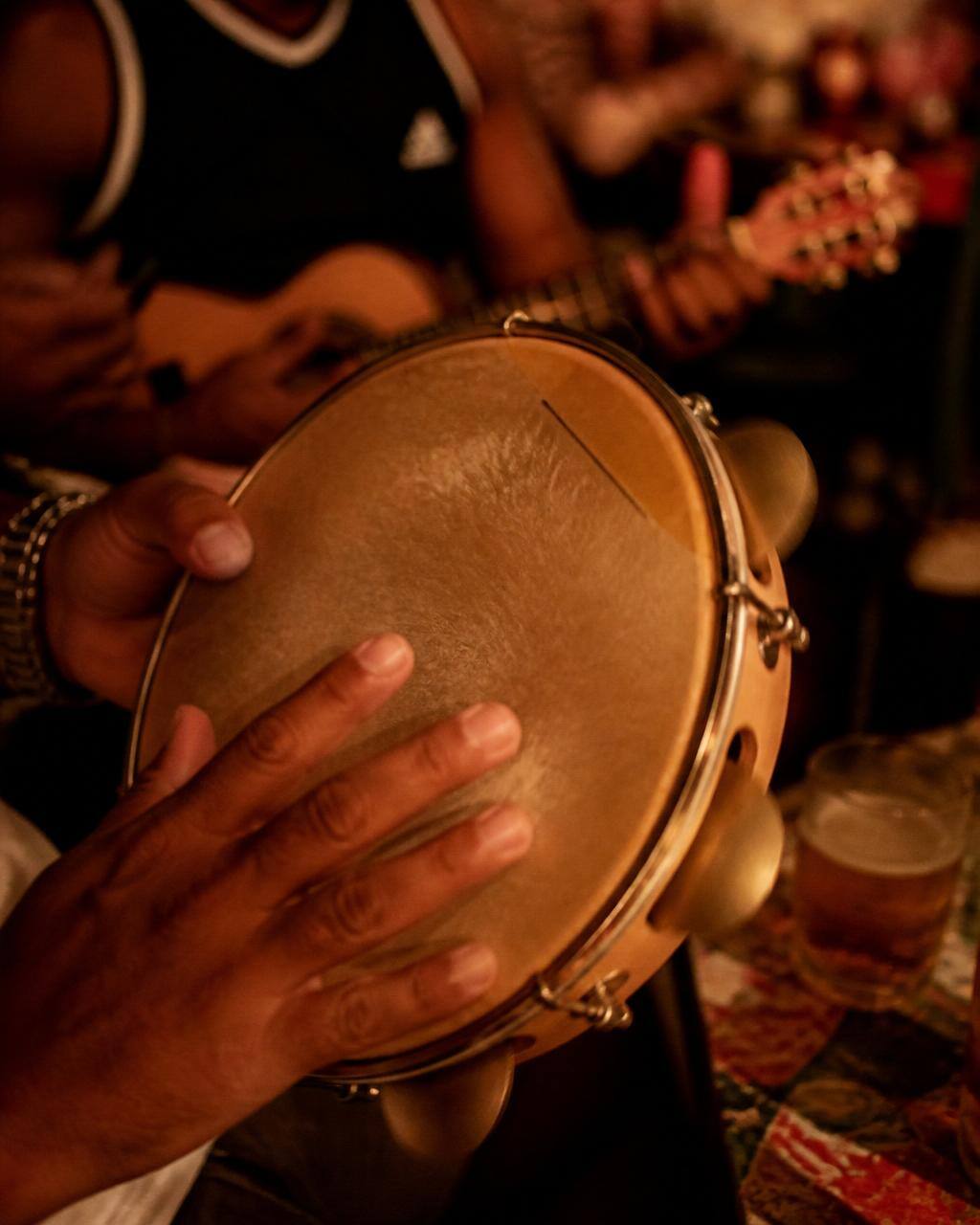 Mão tocando pandeiro em roda de samba